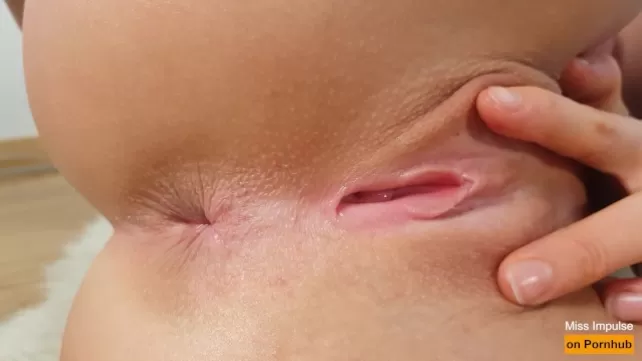 La chica tiene un culo apretado mientras se masturba el coño (primer plano)
