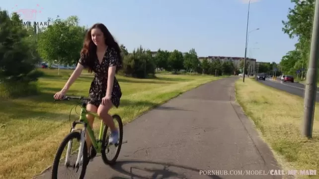 Długowłosa brunetka na rowerze spuści od gumowego Dildo