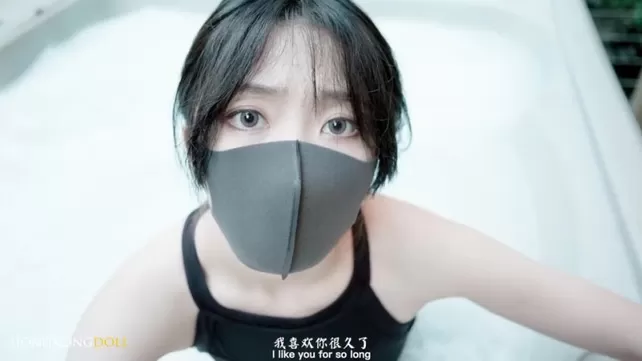 Der Kerl im Bett hat eine junge asiatische Frau in einer Maske im Gesicht gefickt